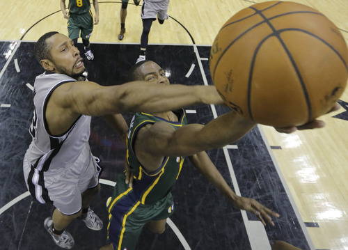 Utah Jazz's Alec Burks, right, is defended by San Antonio Spurs' Boris Diaw, left, of France, as he tries to score during the second half of an NBA basketball game, Sunday, March 16, 2014, in San Antonio. San Antonio won 122-104. (AP Photo/Eric Gay)