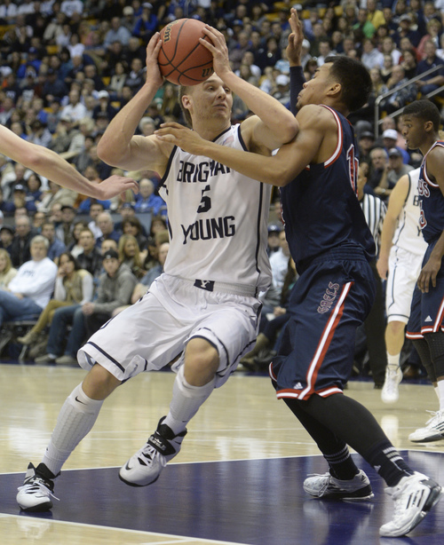 Rick Egan  | The Salt Lake Tribune 

Brigham Young Cougars guard Kyle Collinsworth (5) takes the ball insise, as  St. Mary's Gaels guard Stephen Holt (14) defends, in basketball action, BYU vs. St Mary's, at the Marriott Center, Saturday, February 1, 2014.