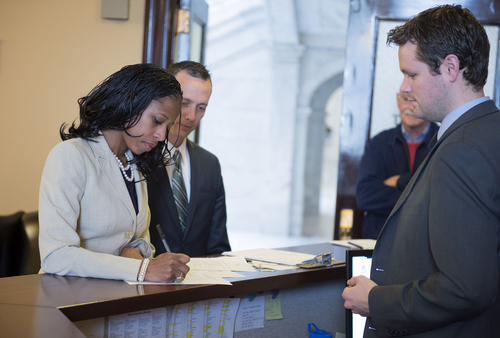 Keith Johnson | The Salt Lake Tribune

Derek Brenchley, right, an administrative assistant with the Utah Lt. Governor's office, receives Mia Love's declaration for candidacy for Utah's 4th District, as  her husband Jason Love and Mia's campaign manager Dave Hansen watch, at the Utah State Capitol in Salt Lake City, March 14, 2014.