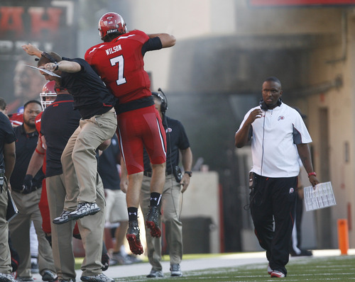Scott Sommerdorf   |  The Salt Lake Tribune
Utah QB Travis Wilson jumps up with a coach on the sidelines after his 3 yard TD pass to Dres Anderson as took a quick 7-0 lead over USU early in the 1st period, Thursday, August 29, 2013. Utah co-OC brian Johnson is at right.