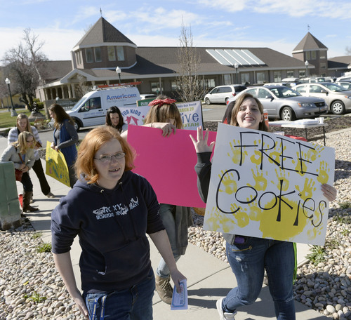 Al Hartmann  |  The Salt Lake Tribune
Volunteers do a honk and wave for Love Utah Give Utah in front of the Christmas Box House at 3660 South West Temple Thursday March 20.  They were giving out free cookies and lemonade along with information about Utah's online "Day of Giving," Love Utah Give Utah.