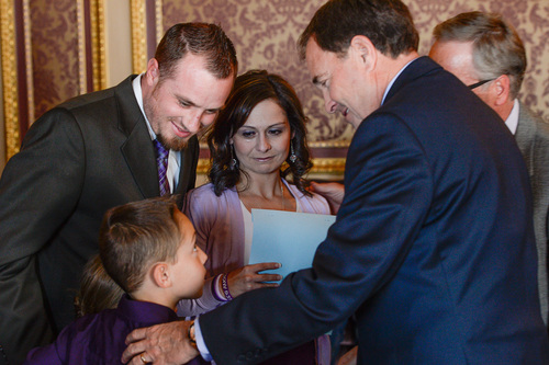 Franciso Kjolseth  |  The Salt Lake Tribune
Jeff and Catrina Nelson alongside their son Jericho, 10, meet with Gov. Gary R. Herbert to sign a ceremonial version of HB105  to legalize the use of nonintoxicating cannabis oil by Utahns with untreatable epilepsy. Their daughter, who could have benefited from the cannabis oil, recently passed away from Late Infant Batten Disease. Families gathered in the Gold Room at the Utah Capitol on Tuesday, March 25, 2014, for the signing. HB105, now called "Charlee's Law," will go into effect on July 1.