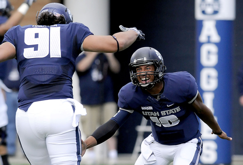 Utah State quarterback Chuckie Keeton (16) celebrates with tight end D.J. Tialavea (91) after throwing a 76-yard touchdown pass during an NCAA college football game against New Mexico State, Saturday, Oct. 20, 2012, in Logan, Utah. (AP Photo/The Herald Journal, Eli Lucero)
