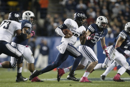 Chris Detrick  |  The Salt Lake Tribune
Utah State Aggies quarterback Chuckie Keeton (16) runs past Brigham Young Cougars defensive lineman Remington Peck (50) during the first half of the game at LaVell Edwards Stadium Friday October 5, 2012. BYU is winning the game 6-3.