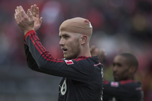 Toronto FC 's Michael Bradley, foreground, and Jermain Defoe applaud supporters after their team's 1-0 win over D.C. United in MLS soccer game action in Toronto, Saturday, March 22, 2014. (AP Photo/The Canadian Press, Chris Young)