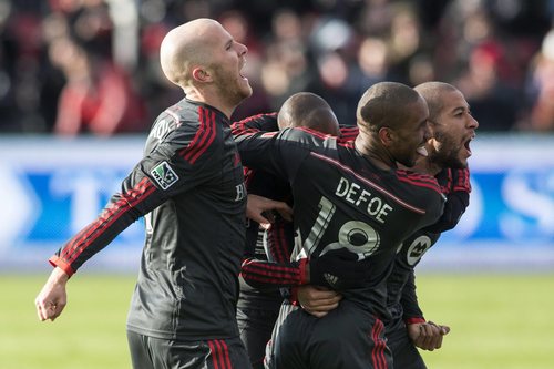 Toronto FC 's Jermain Defoe, second from, celebrates with teammates Justin Morrow, right, and Jackson Goncalves and Michael Bradley, left, after scoring against D.C. United during the second half of an MLS soccer game in Toronto on Saturday, March 22, 2014. (AP Photo/The Canadian Press, Chris Young)