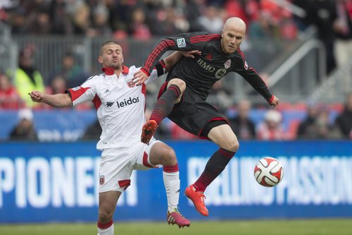 Toronto FC 's Michael Bradley, right, battles for the ball with D.C. United's Perry Kitchen during the first half of an MLS soccer game in Toronto on Saturday, March 22, 2014. (AP Photo/The Canadian Press, Chris Young)