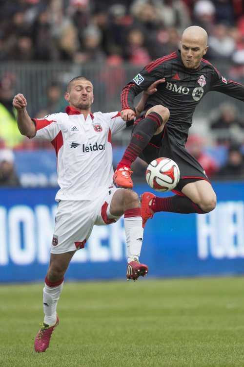 Toronto FC 's Michael Bradley, right,  battles for the ball with D.C. United's Perry Kitchen during the first half of an MLS soccer game in Toronto on Saturday, March 22, 2014. (AP Photo/The Canadian Press, Chris Young)