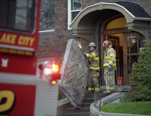Al Hartmann  |  The Salt Lake Tribune
Salt Lake Fire Department responds to an early morning apartment  fire at 53 S. 300 East on Thursday. Firefighters remove a damaged matress from the front door.
