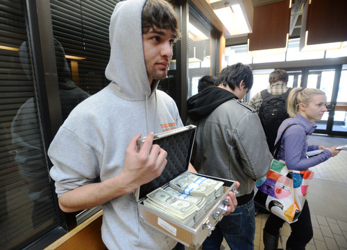 Steve Griffin  |  The Salt Lake Tribune
University of Utah student Luq Mughal holds a briefcase full of $1 bills as he waits in a long line to pay his tuition in January. Mughal paid in $1 bills to protest the high cost of tuition.