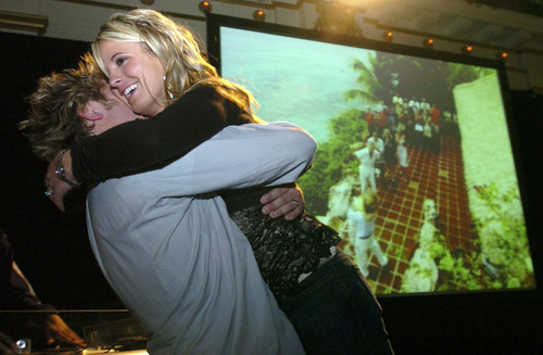 LoveSac founder Shawn Nelson is hugged by his wife, Tiffany, after "The Rebel Billionaire" show names him as the winner, rear, Tuesday, Jan. 11, 2005, in Salt Lake City. (AP Photo/The Salt Lake Tribune, Chris Sinclair)