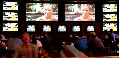 | Tribune File Photo
Neleh Dennis (on screen) is a Finalist in the CBS TV show "Survivor".  Patrons of The SkyBox Sports Grille watch on the many televisions as the game comes to and end.