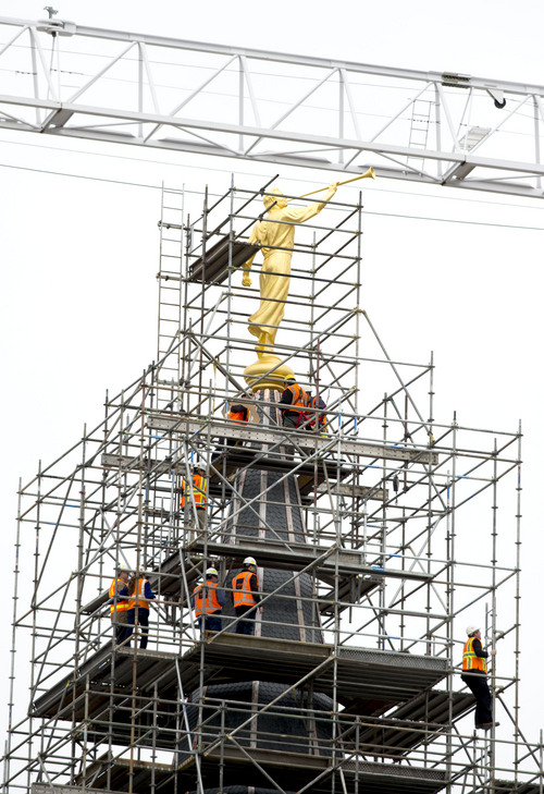Steve Griffin  |  The Salt Lake Tribune
Construction crews work to attach the Angel Moroni statue after a crane lifted it to the top of the Provo City Center Temple in Provo, Utah, Monday, March 31, 2014.