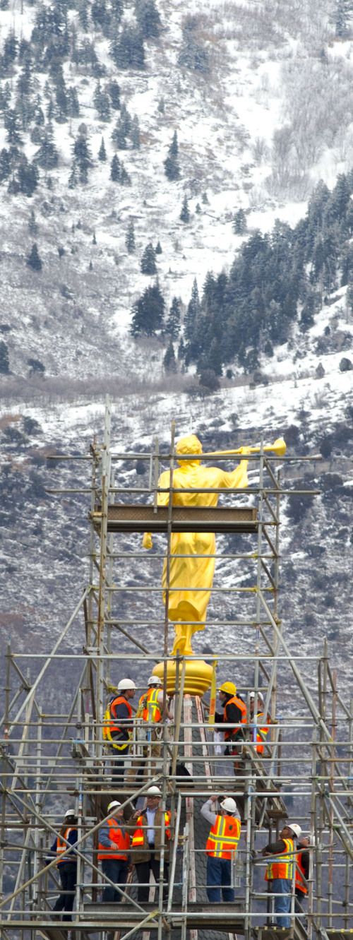 Steve Griffin  |  The Salt Lake Tribune
Construction crews work to attach the Angel Moroni statue after a crane lifted it to the top of the Provo City Center Temple in Provo, Utah, Monday, March 31, 2014.