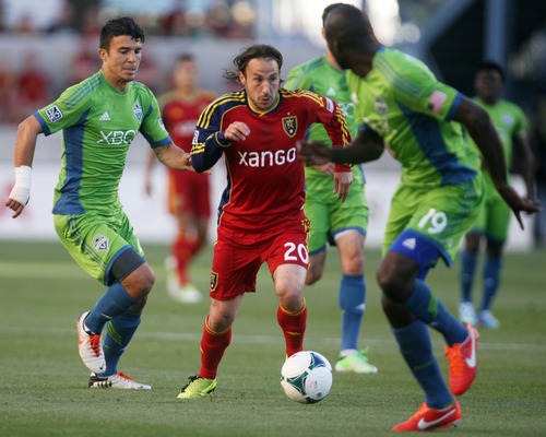 Kim Raff  |  The Salt Lake Tribune
(middle) Real Salt Lake midfielder Ned Grabavoy (20) tries to break free as (left) Seattle Sounders FC midfielder Servando Carrasco (23) and (right)  Seattle Sounders FC defender Djimi Traore (19) defend during the first half of a game at Rio Tinto Stadium in Sandy on June 22, 2013.