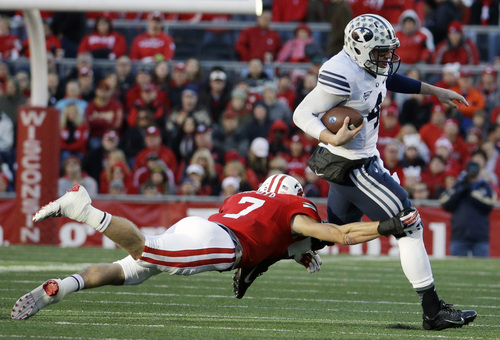 Brigham Young's Taysom Hill, right, tries to break away from Wisconsin's Michael Caputo during the first half of an NCAA college football game on Saturday, Nov. 9, 2013, in Madison, Wis. (AP Photo/Morry Gash)