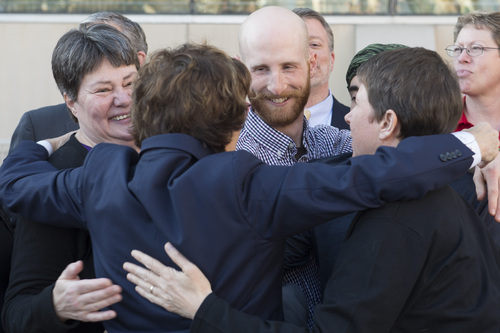 Rick Egan  |  The Salt Lake Tribune

Kate Call, Derek Kitchen and Kody Partidge hug attorney Peggy A. Tomsic, during Utahns United for Marriage "send-off" event Monday night at Library Square, Monday, April 7, 2014