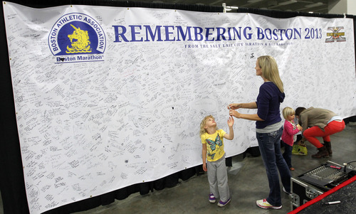 Al Hartmann  |  The Salt Lake Tribune
Brooke Snowball and daughter Haley sign a banner of solidarity and hope to the city of Boston at the Salt Palace Convention Center as she registers for the 2013 Salt Lake City Marathon. Several Utah runners who were near the Boston Marathon's finish line when the blasts went off are returning this year to conquer their fearful memories.