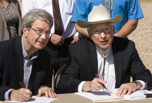 Paul Fraughton / Salt Lake Tribune
Bob Abbey, director of the Bureau of Land Management, and Interior Secretary Ken Salazar -- appearing at pipline compressor station in west Salt Lake City -- sign approval for 3,675-well expansion of natural-gas drilling in eastern Utah. Tuesday, May 8, 2012
