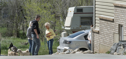 Steve Griffin  |  The Salt Lake Tribune

Sandee Wall, a next door neighbor, center, talks with a man and women at the house where seven dead infants were found April 13, 2014 in this Pleasant Grove, Utah home. Police believe Megan Huntsman, 39, gave birth to the babies then killed them over the past decade.