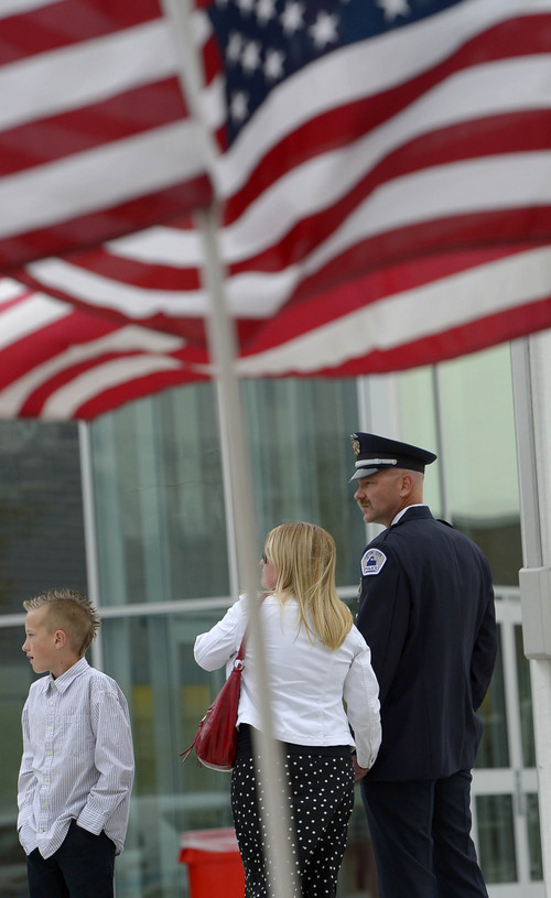 Leah Hogsten  |  The Salt Lake Tribune
Layton Police Department officer Ted Donoviel, wife Emily and son Hayden, 12, amid the flags place outside Granger High School. Donoviel was honored during ìUtah Heroes Night,î hosted by the Utah Fraternal Order of Police that honored 20 Utah officers for their heroic actions taken last year at Granger High School, Tuesday, April 15, 2014.