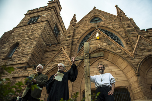 Chris Detrick  |  The Salt Lake Tribune
Rev. Michael J. Imperiale, Pastor of First Presbyterian Church, speaks as Alex Bury holds a wooden cross during the annual interfaith Good Friday processional Friday April 18, 2014. Since 1983, the Salt Lake Council of Churches has sponsored this annual procession, which is similar to the tradition of the "Via Dolorosa" (Way of Suffering), where pilgrims to Jerusalem follow the path Jesus took to the cross. At left is The Very Rev. Martin Diaz, The Cathedral of the Madeleine.