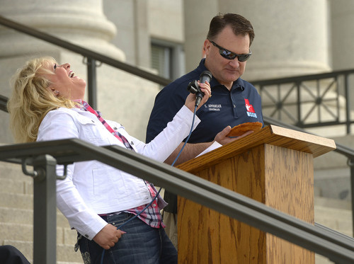 Leah Hogsten  |  The Salt Lake Tribune
l-r Janalee Tobias laughs as she challenges Clark Aposhian to eat a piece of pizza into the shape of a gun to illustrate the absurdity of a high school student receiving punishment for doing the exact same thing. The Pro Gun, Pro Constitution, Anti-tyranny Rally supporters gathered on the Utah Capitol south steps on the anniversary of Patriots Day, Friday, April 19, 2014.