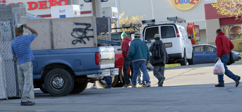 Al Hartmann  |  The Salt Lake Tribune
Workers gather around contractors' trucks at a gas station across the street from Home Depot at 2100 South and 300 West.  They are looking to be hired for the day.  Sometimes there are confrontations between security guards and laborers who at times almost ring the parking lot near the Home Depot. Customers who park too close to laborers may find themselves swarmed.  Contractors can negotiate with the waiting men and fill trucks with workers in under 10 seconds.