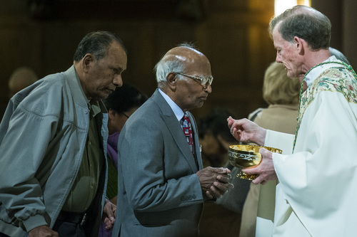 Chris Detrick  |  The Salt Lake Tribune
Saman Lall receives communion from the Rev. John C. Wester, bishop of Salt Lake City, during the Mass of the Lord's Supper at the Cathedral of the Madeleine on Thursday, April 17, 2014.