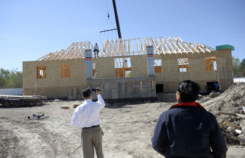 Al Hartmann  |  The Salt Lake Tribune
Members of the Cambodian community watch as roof joists are raised for a  new Buddhist temple, called Sala Chhan, in West Valley City Thursday April 17.