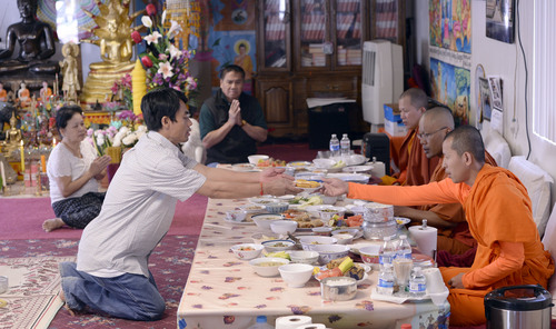 Al Hartmann  |  The Salt Lake Tribune
Members of the Cambodian community perform their daily prayers and honor their Buddhist monks with food at their West Valley City temple. They have met in this large converted garage in West Valley City for many years.  Now, they are raising money to construct a larger building, called Sala Chhan, that will include the temple and classrooms.