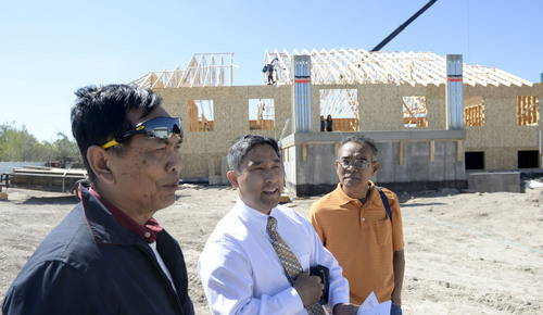 Al Hartmann  |  The Salt Lake Tribune
Cambodian community leaders Vanny Nhem, left,  Ray Hour, and Saroeun Keo watch as roof joists are raised for a new Buddhist temple in West Valley City Thursday April 17.