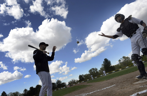 Scott Sommerdorf   |  The Salt Lake Tribune
Highland High assistant coach Spencer Matherson, left, runs infield practice prior to a game between Highland and Woods Cross in Sugar House Park, Wednesday, April 23, 2014. The catcher tossing him a baseball is Austin Brown.