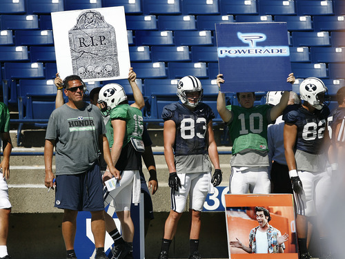 Scott Sommerdorf   |  The Salt Lake Tribune
BYU OC Robert Anae, left, watches practice as his players hold up two of many boards that signal plays in to his speeded up offense during football practice at BYU, Wednesday, August 21, 2013.