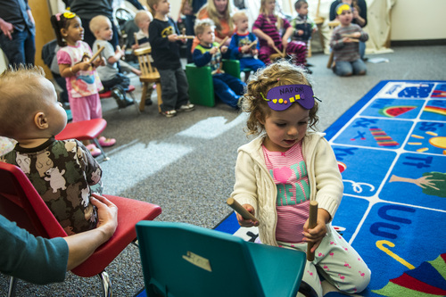 Chris Detrick  |  The Salt Lake Tribune
Reese Dickamore, 3, of South Jordan, and Andrew Dickamore, 15 months, left, play drums with wooden sticks during 'Literacy Night' at Kauri Sue Hamilton School Child Development Center Tuesday April 29, 2014. Families of special needs children who are part of the Early Intervention Program, age birth to 3-years-old, received a copy of the 'Napping House' by Audrey Wood and participated in activities throughout the evening  highlighted parts of the book.