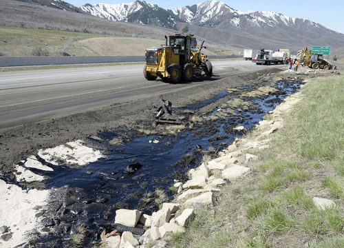 Al Hartmann  |  The Salt Lake Tribune
UDOT crews create berms and absorb crude oil from oil tanker truck the crashed and spilled oil on westbound I-80 near the Lambs Canyon exit in Parley's Canyon Wednesday April 30.  Some oil seeped into a storm drain before it was contained.