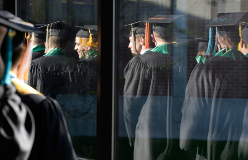 Franciso Kjolseth  |  The Salt Lake Tribune
The 2014 class at Utah Valley University is reflected in the glass as they walk the halls of campus to commencement ceremonies at the UCCU Center on Thursday, May 1, in Orem.