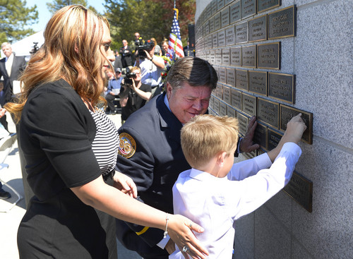 Leah Hogsten  |  The Salt Lake Tribune
l-r Shante Johnson, wife of Draper Police Sgt. Derek Johnson, son Bensen, 7, and retired Orem Police Chief Clark Christensen place Johnson's nameplate. Johnson and Utah County Sheriffís Sgt. Cory Wride's names  were added to the Utah Fallen Officer Memorial in a ceremony, Thursday, May 1, 2014 on the State Capitol grounds.