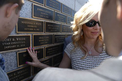 Leah Hogsten  |  The Salt Lake Tribune
l-r Sheriff's Sgt. Cory Wride's wife Nanette touches her husband's nameplate.  Draper Police Sgt. Derek Johnson and Utah County Sheriff's Sgt. Cory Wride's names  were added to the Utah Fallen Officer Memorial in a ceremony, Thursday, May 1, 2014 on the State Capitol grounds.