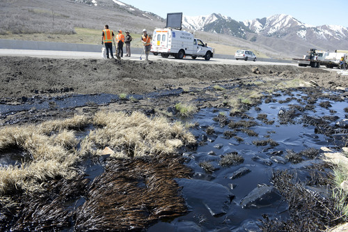 Al Hartmann  |  The Salt Lake Tribune
UDOT crews create berms and absorb crude oil from an oil tanker truck that crashed and spilled oil on westbound I-80 near the Lambs Canyon exit in Parley's Canyon Wednesday April 30, 2014. Some oil seeped into a storm drain before it was contained.