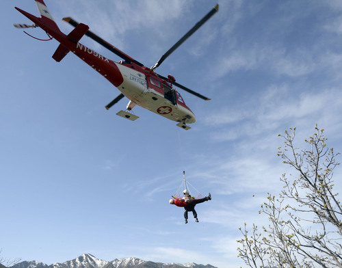 Al Hartmann  |  The Salt Lake Tribune
Curtis Andersen, flight paramedic with Life Flight, rises on a hoist line with Utah County Search and Rescue's Toby Norton, (playing an injured person) in a rescue net, during a practice drill at Little Dell Reservoir Monday May 5, 2014. Paramedics and Life Flight crews practiced a series of "live" hoist rescues to prepare for the upcoming summer season. The hoist rescues covered a number of scenarios in which injured recreationalists are injured or stranded and need to be airlifted to safety. Intermountain Life Flight is the first and only civilian air ambulance in the nation equipped and licensed to perform hoist rescues. A paramedic is lowered to an injured or stranded person on a specially designed hoist attached to the helicopter. Life Flight operates Agusta twin-engine helicopters equipped for hoist operations that are well suited for high-altitude performance.