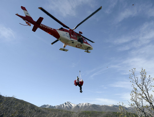 Al Hartmann  |  The Salt Lake Tribune
Curtis Andersen, flight paramedic with Life Flight, rises on a hoist line with Utah County Search and Rescue's Toby Norton, (playing an injured person) in a rescue net, during a practice drill at Little Dell Reservoir Monday May 5, 2014. Paramedics and Life Flight crews practiced a series of "live" hoist rescues to prepare for the upcoming summer season. The hoist rescues covered a number of scenarios in which injured recreationalists are injured or stranded and need to be airlifted to safety. Intermountain Life Flight is the first and only civilian air ambulance in the nation equipped and licensed to perform hoist rescues. A paramedic is lowered to an injured or stranded person on a specially designed hoist attached to the helicopter. Life Flight operates Agusta twin-engine helicopters equipped for hoist operations that are well suited for high-altitude performance.