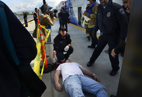 Scott Sommerdorf   |  The Salt Lake Tribune
First responders care for some of the "wounded" after they were evacuated from passenger rail cars during a training exercise. The Utah Transit Authority held a terrorism bombing drill at the Murray Central Station in conjunction with Intermountain Medical Center, Thursday, May 8, 2014.