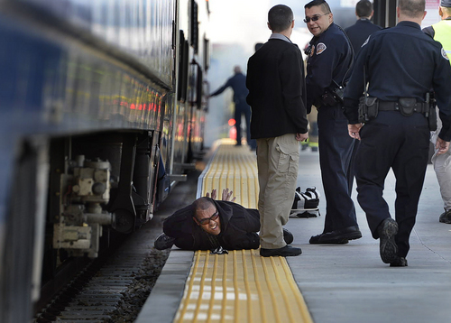 Scott Sommerdorf   |  The Salt Lake Tribune
Police apprehended the "bad guy" in a training drill next to the FrontRunner train. The Utah Transit Authority staged the terrorism bombing drill at the Murray Central Station in conjunction with Intermountain Medical Center, Thursday, May 8, 2014.