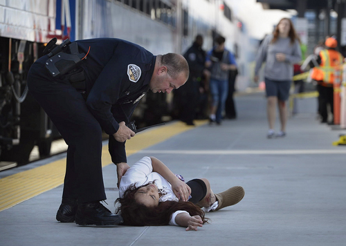 Scott Sommerdorf   |  The Salt Lake Tribune
A Murray police officer tends to an injured "victim" as UTA held a terrorism bombing drill at the Murray Central Station in conjunction with Intermountain Medical Center, Thursday, May 8, 2014.