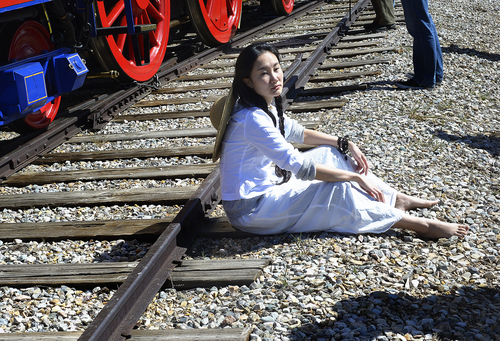 Scott Sommerdorf   |  The Salt Lake Tribune
Dancer Wan Zhao sits beside one of the railroad tracks that leads to the Golden Spike comemmoration ceremony, Saturday, May 10, 2014. The Chinese community honored Chinese immigrants who built the railroad from the west by taking more than three busloads of people to the Golden Spike National Monument for the 145th commemoration of the completion of the transcontinental railroad.