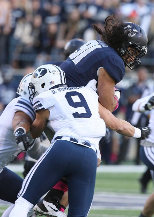 Leah Hogsten | The Salt Lake Tribune
Brigham Young Cougars linebacker Uani 'Unga (41) and Brigham Young Cougars defensive back Daniel Sorensen (9) bring down Utah State Aggies tight end D.J. Tialavea (91).  Brigham Young University Cougars lead 10-7 after the first quarter during their matchup against  Utah State University Aggies  Friday, October 4, 2013 in Logan.