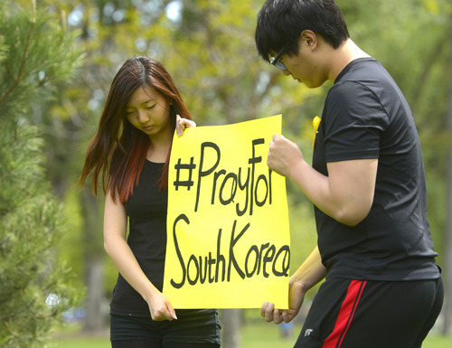 Rick Egan  |  The Salt Lake Tribune

Elizabeth Park and Jay Yoon hold a sign in honor of the victims of the South Korea ferry disaster, during a rally at Liberty Park, Sunday, May 18, 2014.  The rally was held to remember, honor and pray for victims and families of the South Korea ferry disaster that killed more than 300 people, mostly high school students, on April 26. It was organized by Korean ex-patriots living in Utah as part of a 50-state rally organized by Missy USA, a social website catering to Korean and Korean American women in the U.S.