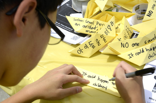 Rick Egan  |  The Salt Lake Tribune

Ryan Shin, 13, makes paper boats, in honor of the victims of the South Korea ferry disaster, during a rally at Liberty Park, Sunday, May 18, 2014.  The rally was held to remember, honor and pray for victims and families of the South Korea ferry disaster that killed more than 300 people, mostly high school students, on April 26. It was organized by Korean ex-patriots living in Utah as part of a 50-state rally organized by Missy USA, a social website catering to Korean and Korean American women in the U.S.