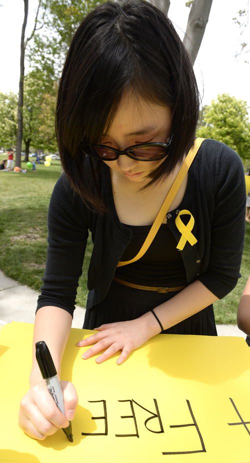Rick Egan  |  The Salt Lake Tribune

Stephanie Shin makes a sign in honor of the victims of the South Korea ferry disaster, during a rally at Liberty Park, Sunday, May 18, 2014.  The rally was held to remember, honor and pray for victims and families of the South Korea ferry disaster that killed more than 300 people, mostly high school students, on April 26. It was organized by Korean ex-patriots living in Utah as part of a 50-state rally organized by Missy USA, a social website catering to Korean and Korean American women in the U.S.